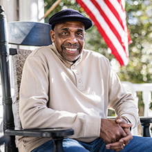 A veteran in a wheelchair in front of flag